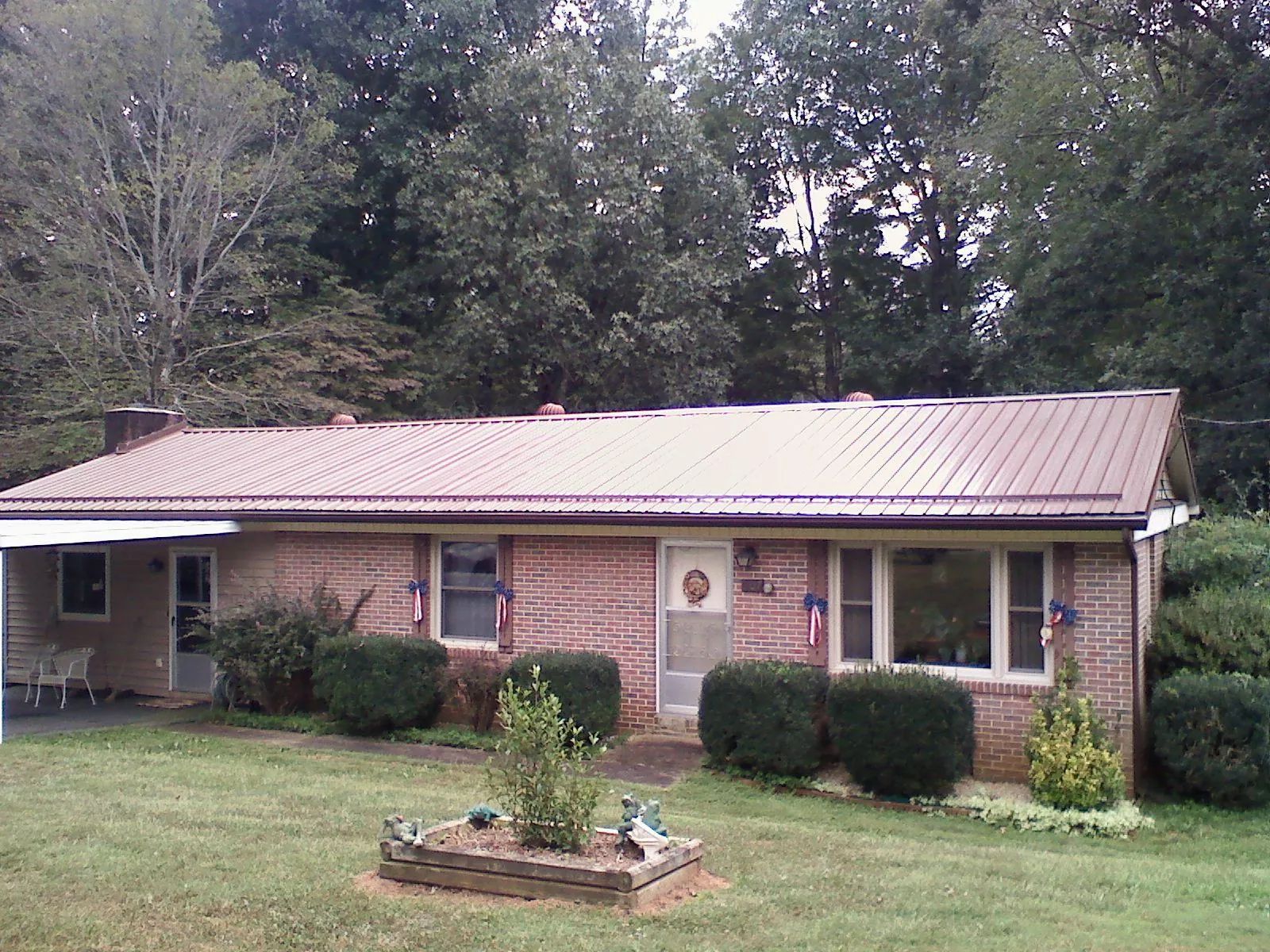 Bronze metal roof on a brick ranch home with a carport in Mongaup Valley
