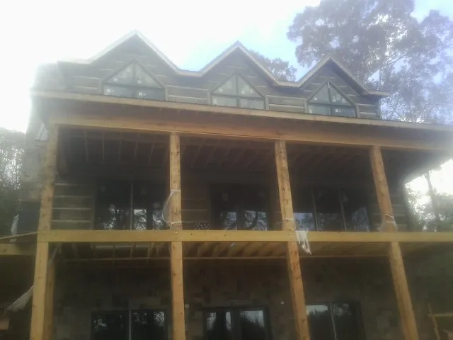 Dormers and porch framing on a large log home under construction — Roof Coating work by our crew in Mongaup Valley
