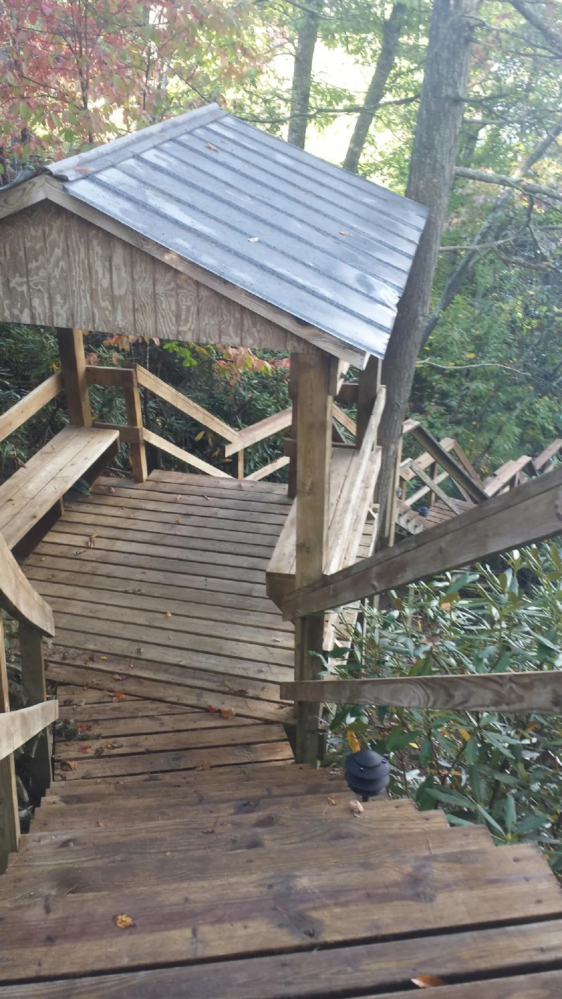 Metal roofed shelter over wooden steps on a wooded walkway — Skylight Repair & Installation work by our crew in Mongaup Valley